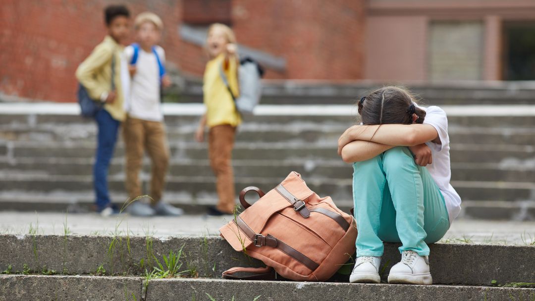 A girl sitting alone outside school